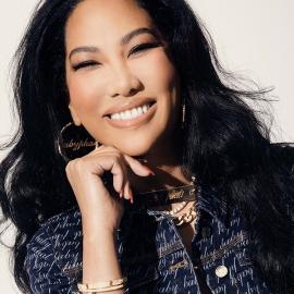 Kimora Lee Simmons smiling and posing with her right hand under her chin