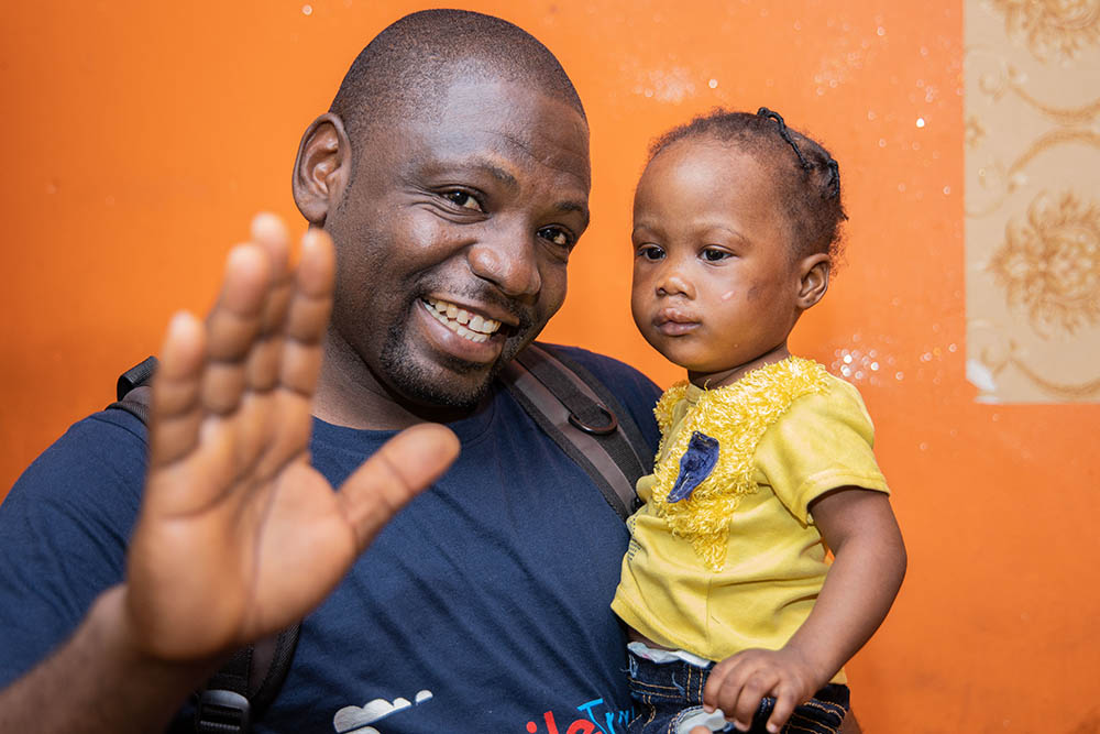 Paul Lobi smiling and holding a patient