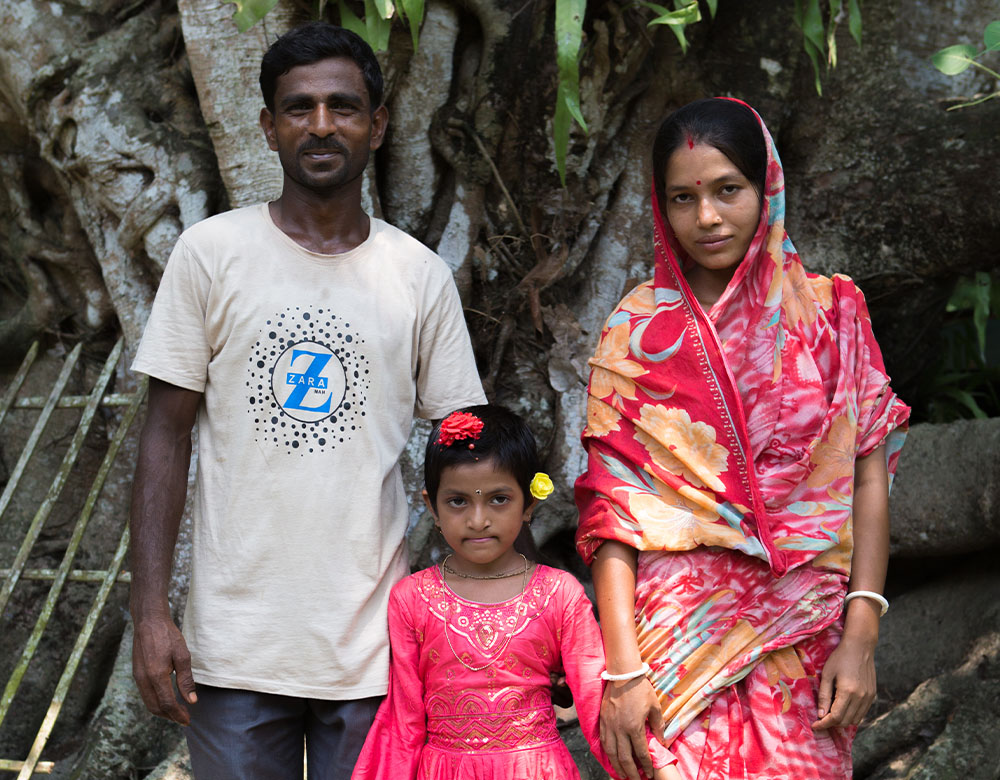 Disha standing in front of Sathi and Doyal after cleft surgery