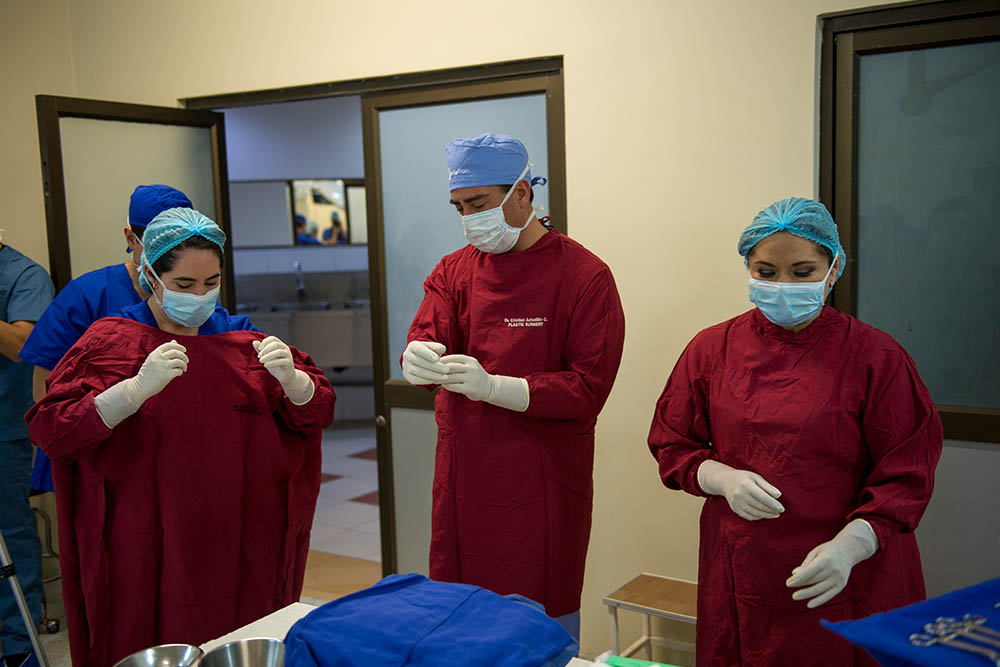 Andrea and Cristian put on their scrubs