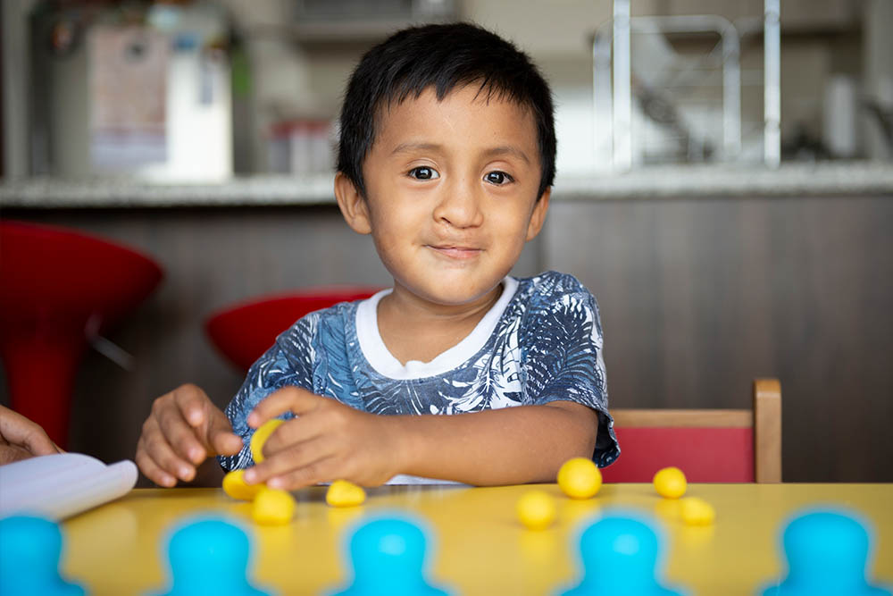 Anthony at a table ready for speech therapy session