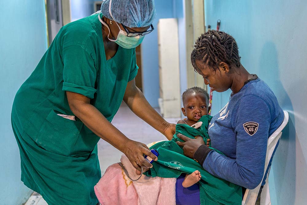 A child taken by a nurse for cleft surgery