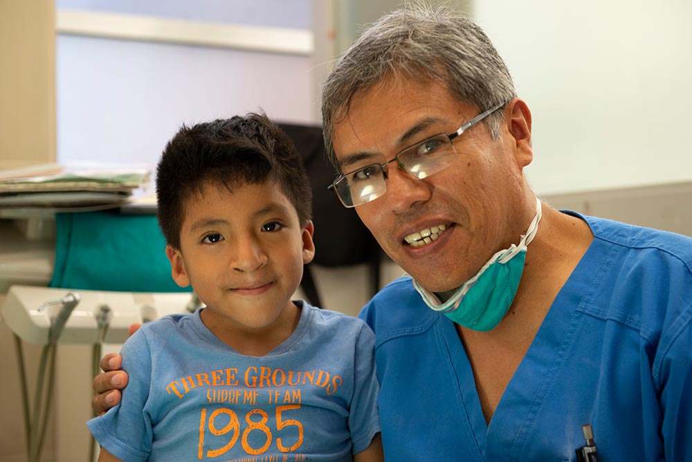 Dr Meza smiles with a happy dental patient