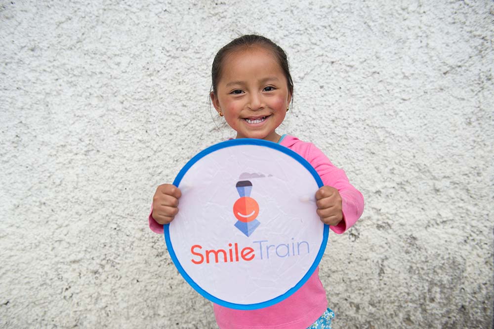 Fernanda holds up Smile Train sign