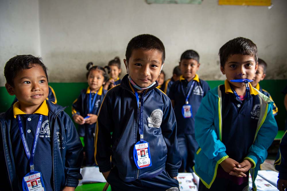 Jenious in school standing with his friends