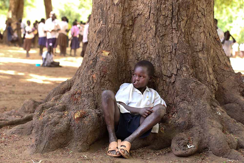 Kamse hides behind a tree during recess 