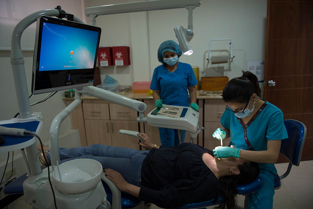 Maria working on patient in dentist chair