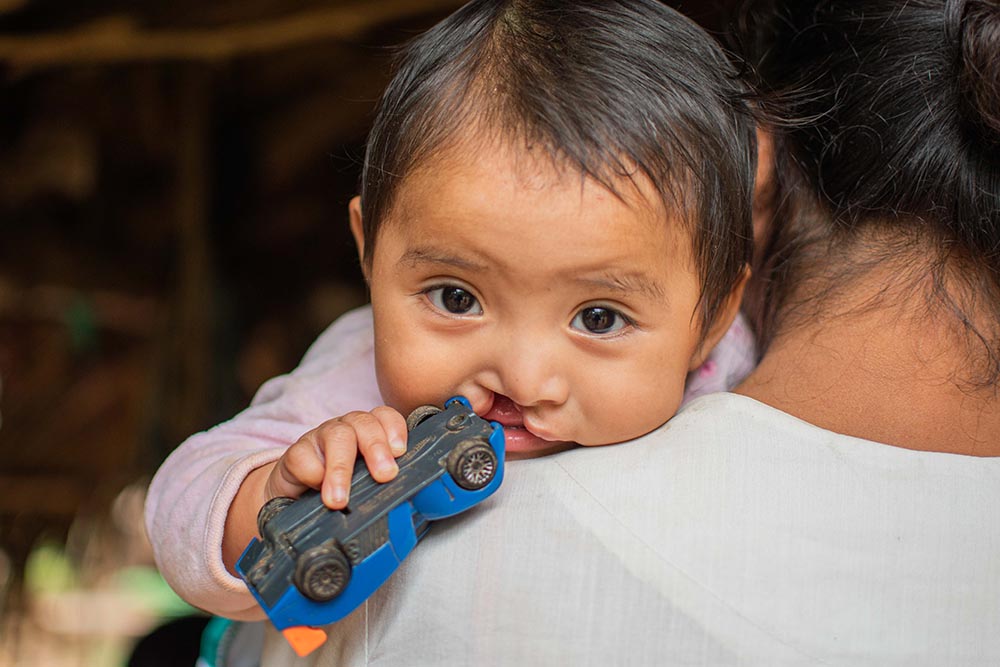 Mirian with a toy car in her mouth