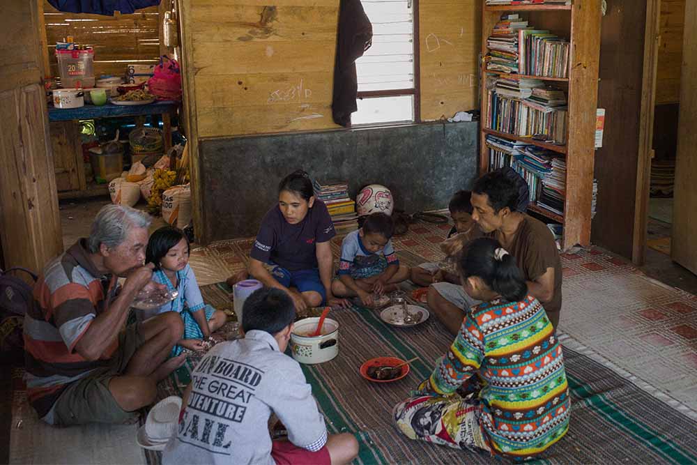 Natsir's family eating on the floor of his home