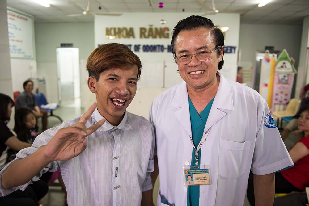 Nguyen Van Dau with a former patient giving a peace sign