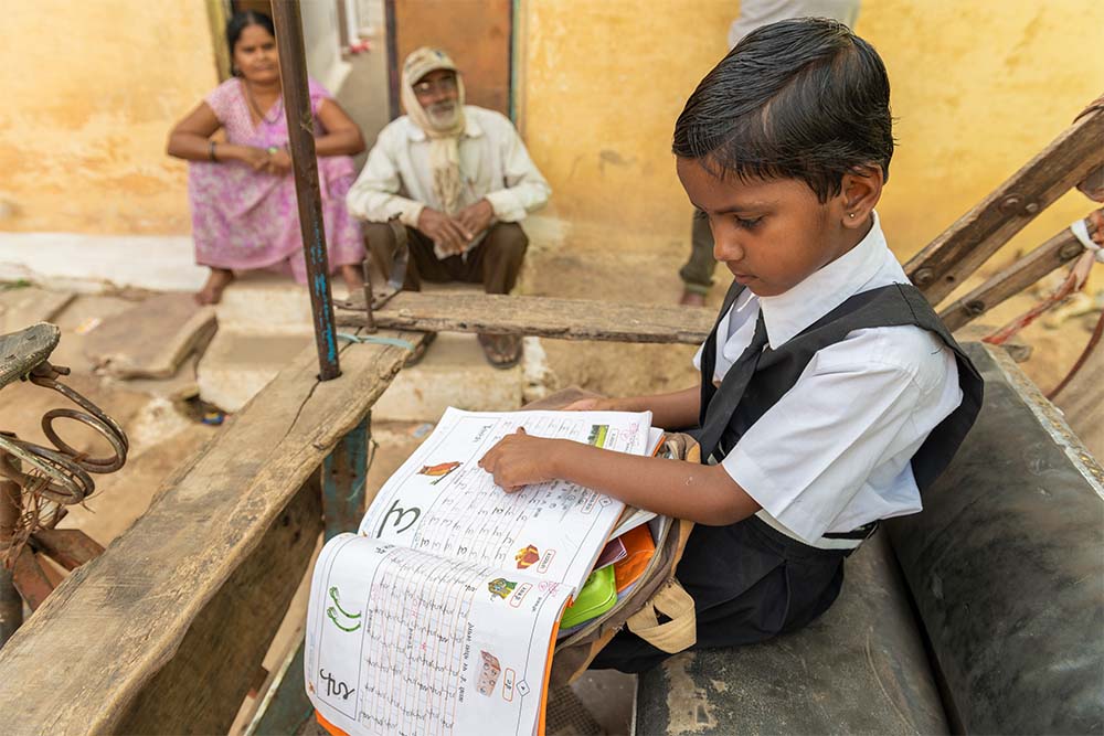 Saraswati points to her school book 