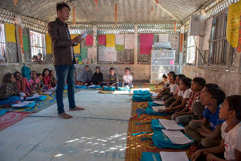 Teacher speaks to students at the refugee camp school