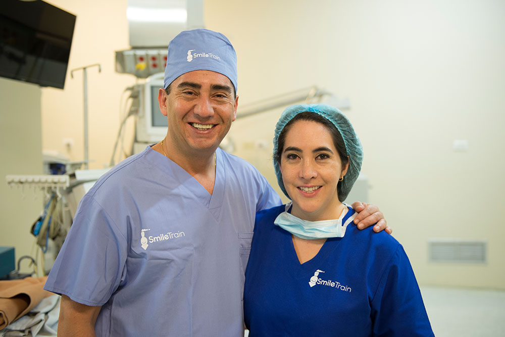 Brother and sister pose in Smile Train scrubs