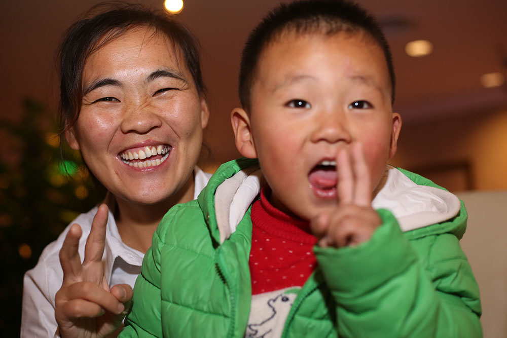 Wang Li and her child both giving peace signs to camera