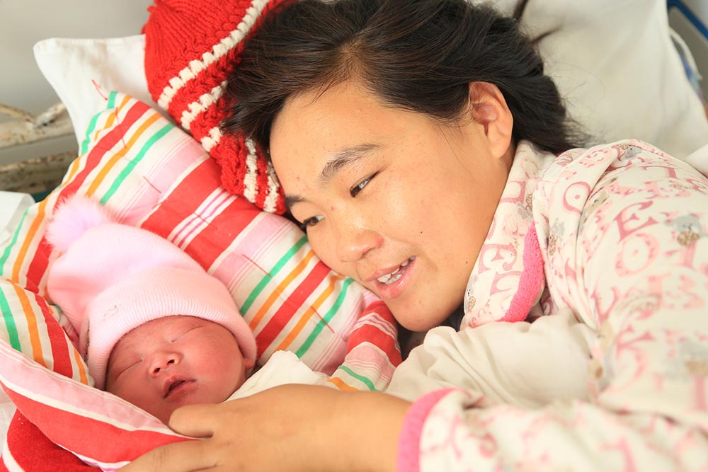 Wang Li next to her newborn baby