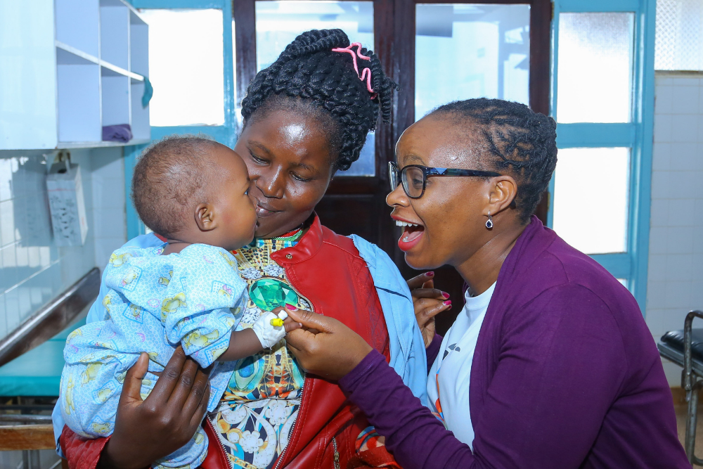 Esther greets a child with a cleft with a smile