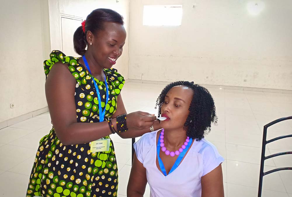 Participant spoon feeds another person at workshop