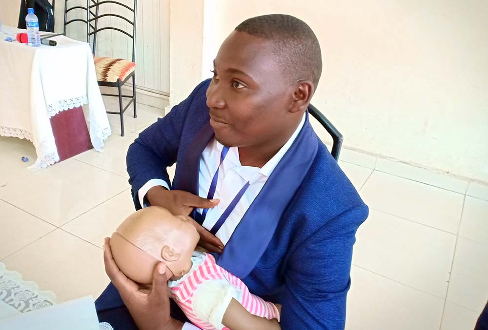 Man practices breastfeeding on toy baby