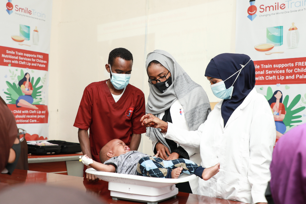 Healthcare workers weighing baby