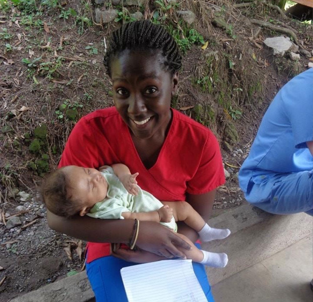 Christian Henry holds a baby in Honduras