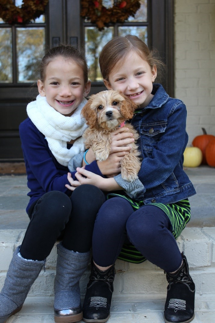 Arden and Finley hug their puppy