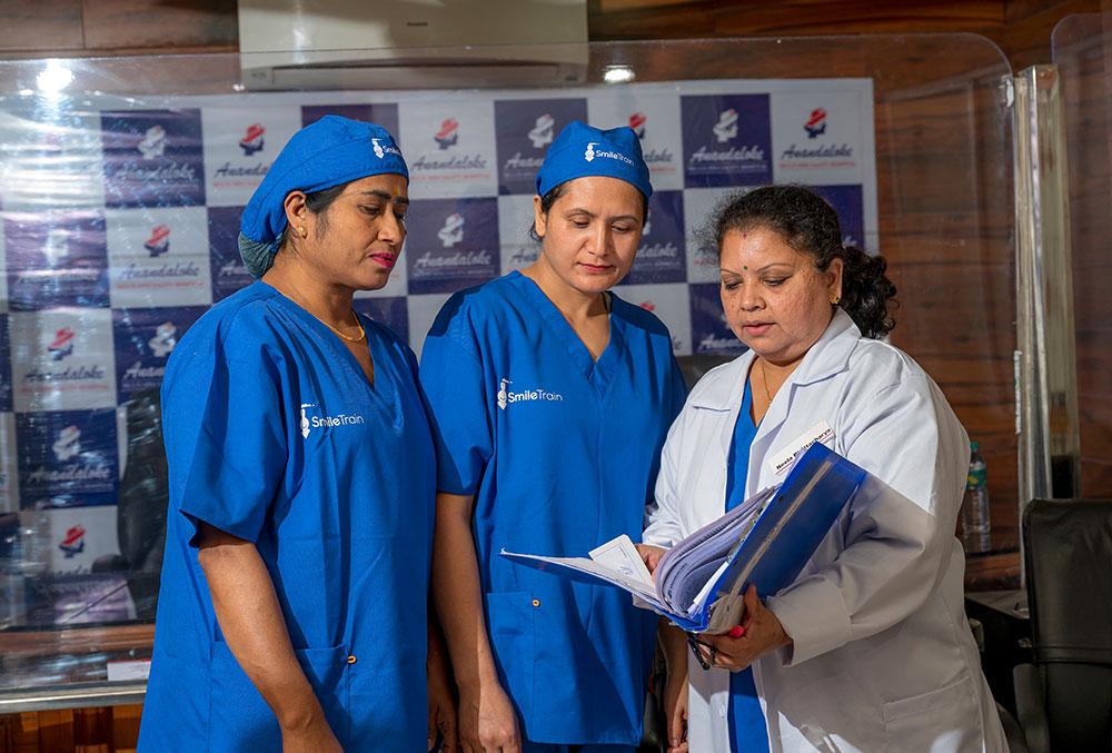 Dr. Neela discussing patient records with her staff