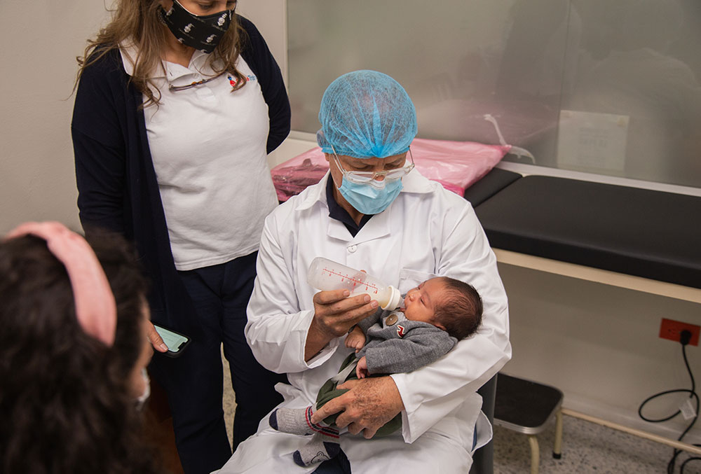 A doctor at FISULAB feeding a patient with a specialized bottle