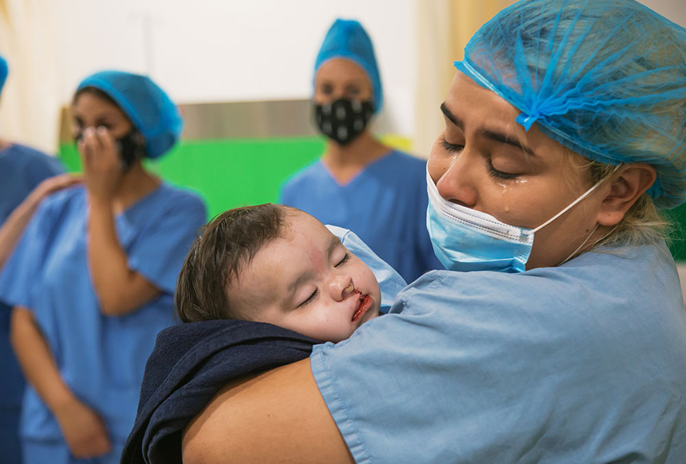 Alejandra crying as she holds Celeste just after her cleft surgery