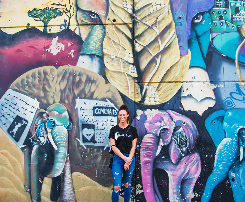 Christine poses with graffiti in Comuna 13 