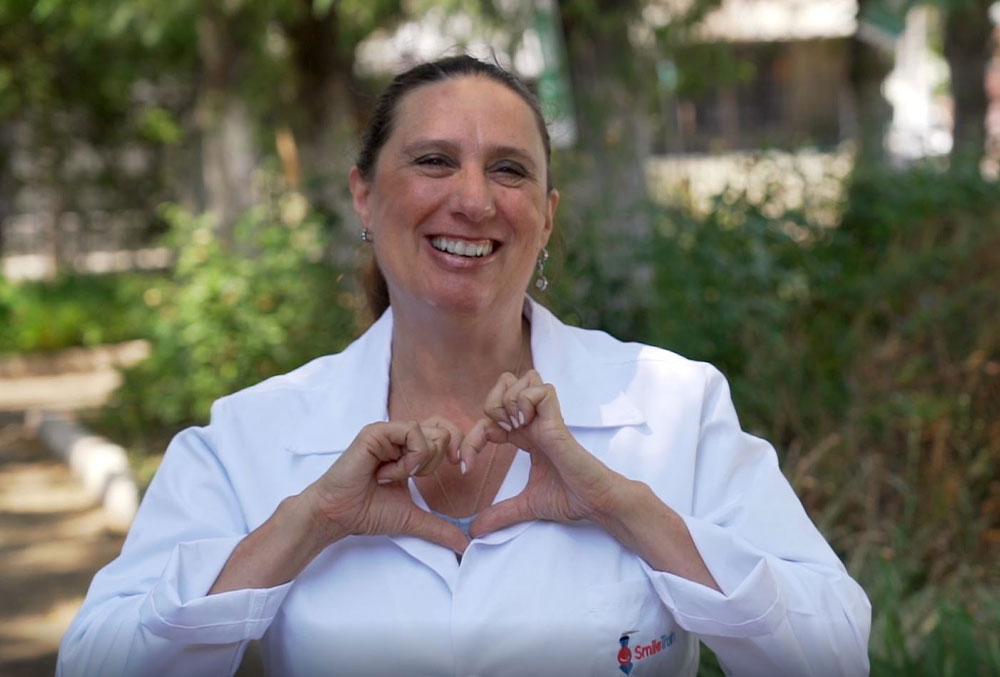 Dr. Maria Campodónico, a pediatric dentist at Fundación Gantz, makes a heart with her hands