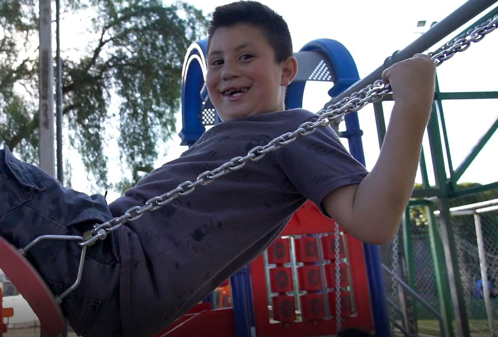 Amaro smiling on a swing