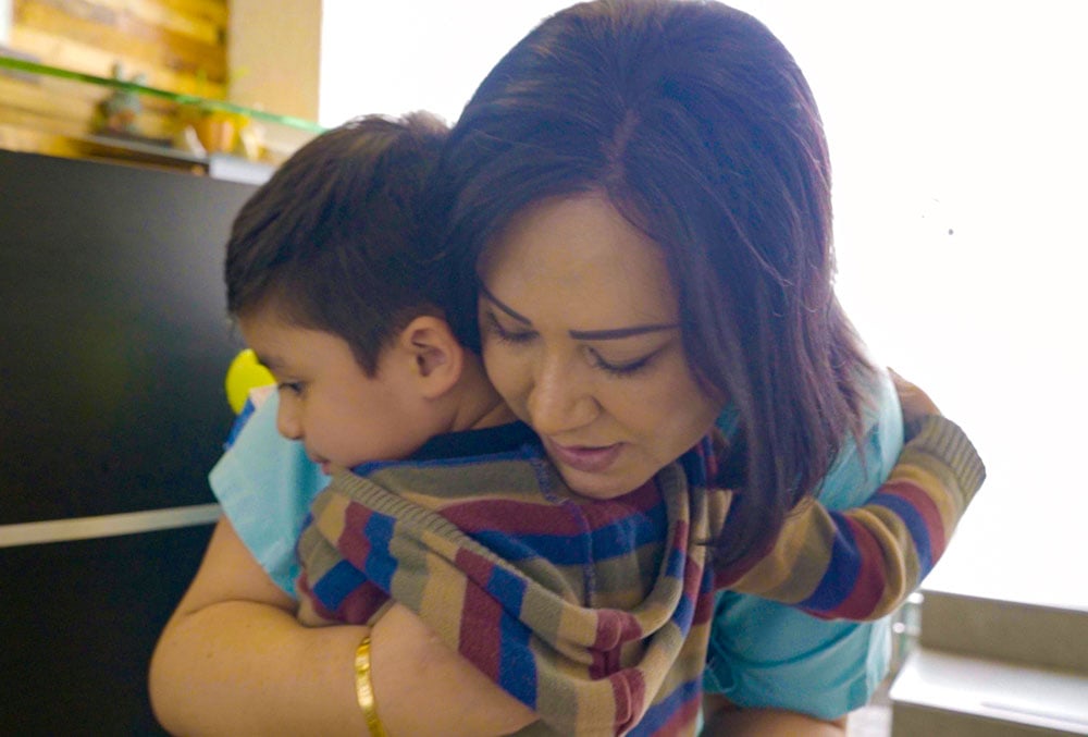 Dr. Karina Cabal hugging Damian at Centro SUMA