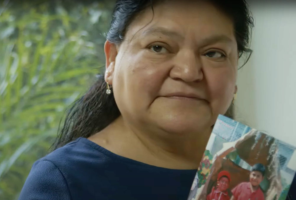 Eduardo's mother holding a picture of him as a child