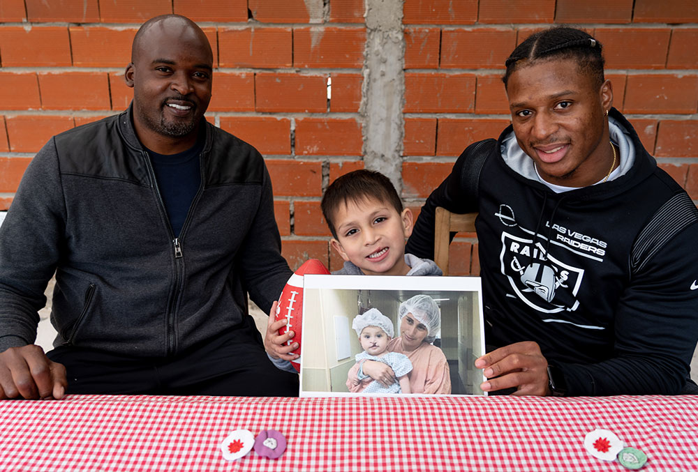 Mathias and Kenyan with Smile Train patient Benicio, who is holding a picture of himself before cleft surgery