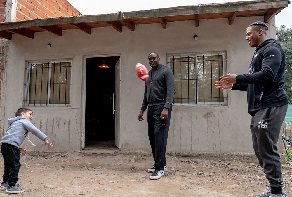 Kenyan and Mathias throw a football around with Benicio