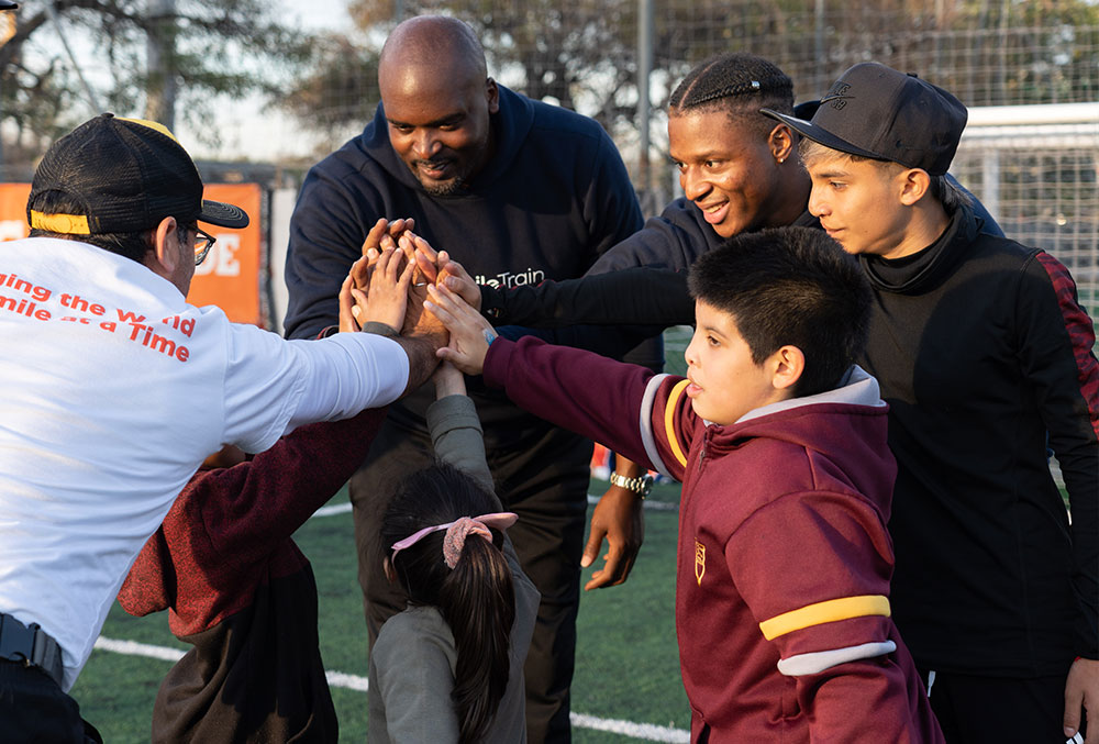 Kenyan and Mathias breaking a huddle at their football clinic