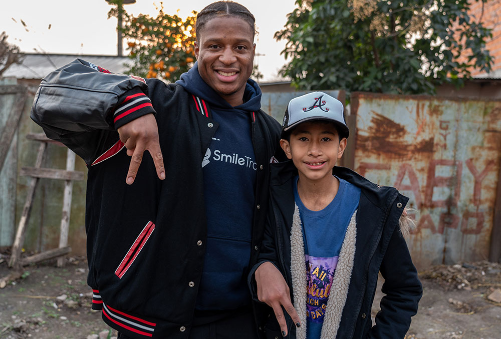 Kenyan posing with a patient at his home