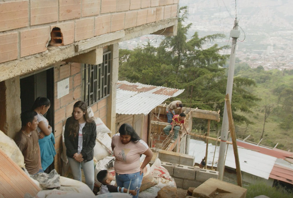 Camila Osorio speaking with Jose and Yesica outside their home