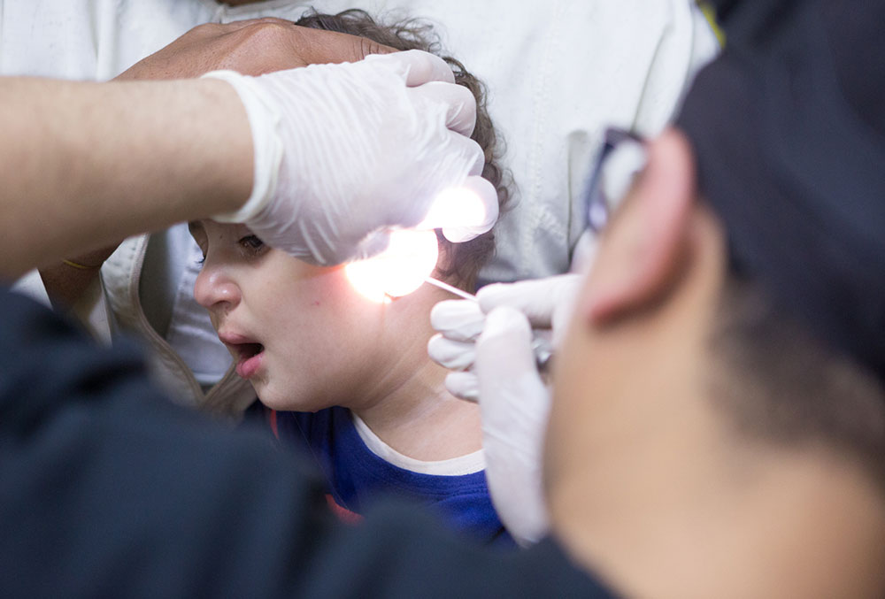 Dr. Tarek examining a patient's ears