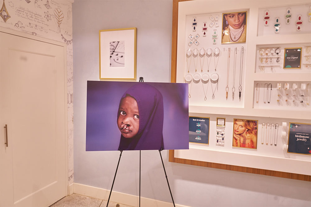 A picture of a Smile Train patient on an easel at the NYC Kendra Scott store on Giving Tuesday
