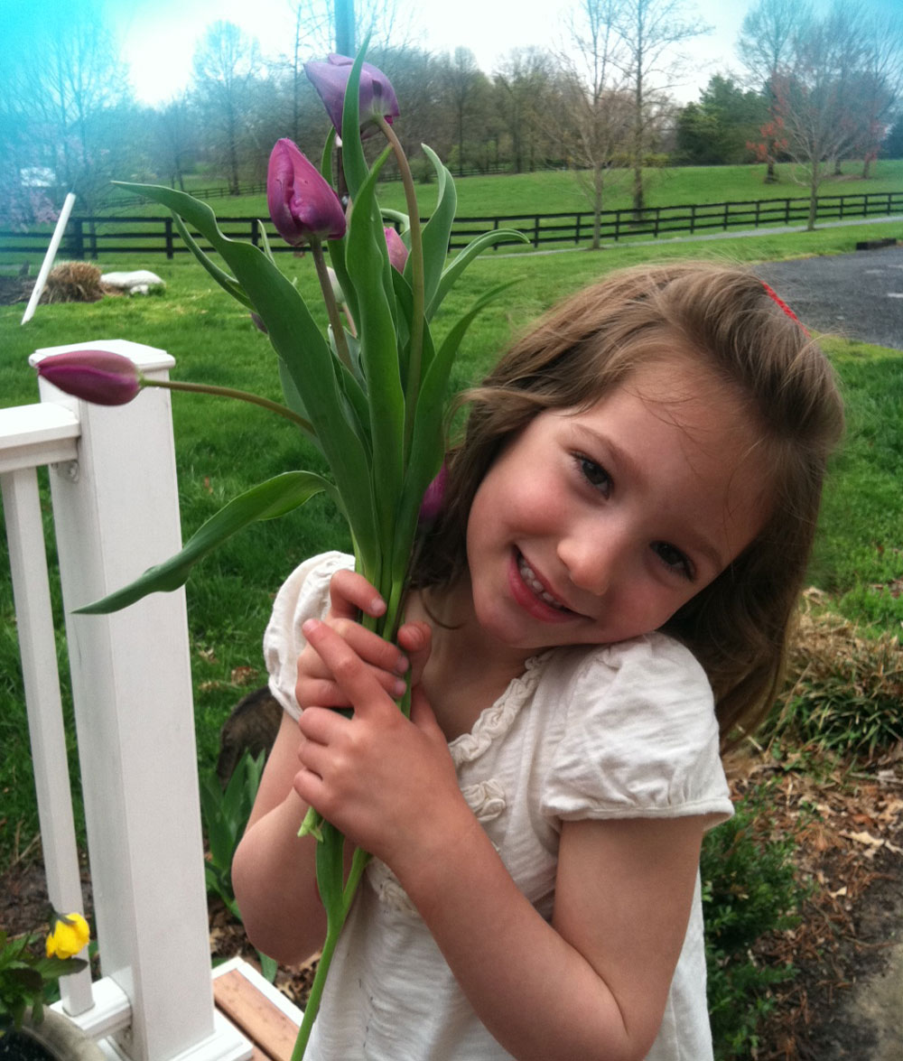 Sadie smiling and holding purple flowers