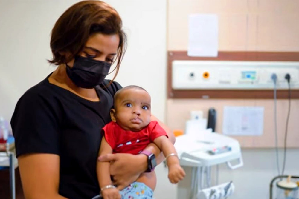 Dr. Shruti holding a baby with a cleft