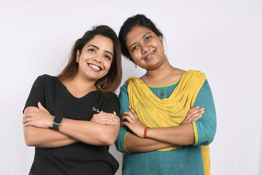 Dr. Shruti smiling and touching heads with a teenage patient