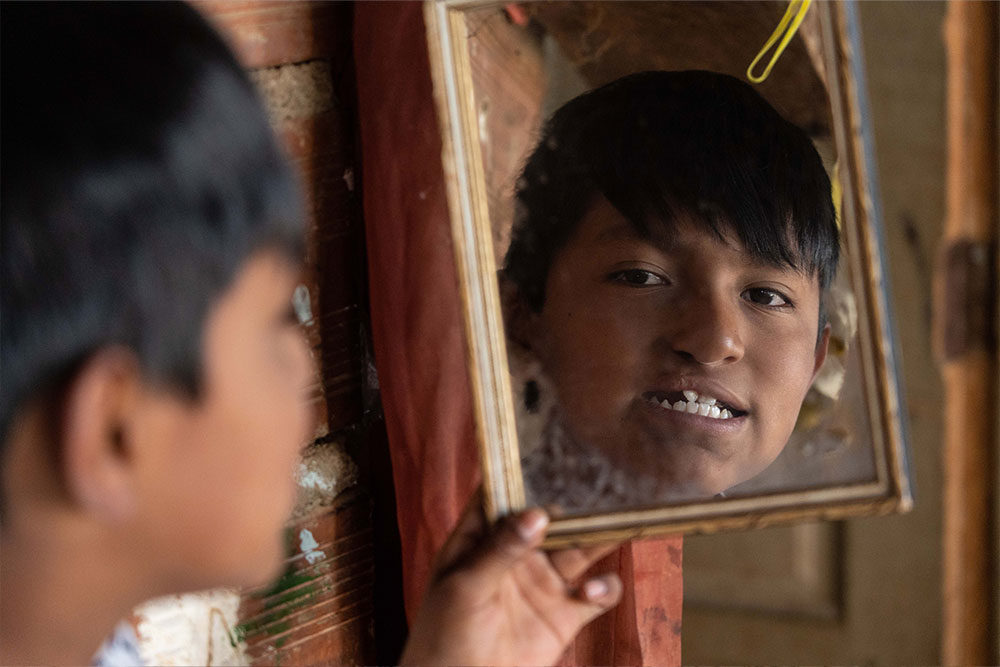 Luis today, smiling in a hand mirror