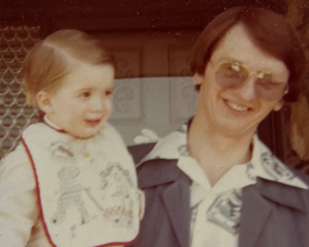 David’s dad holding a smiling young David