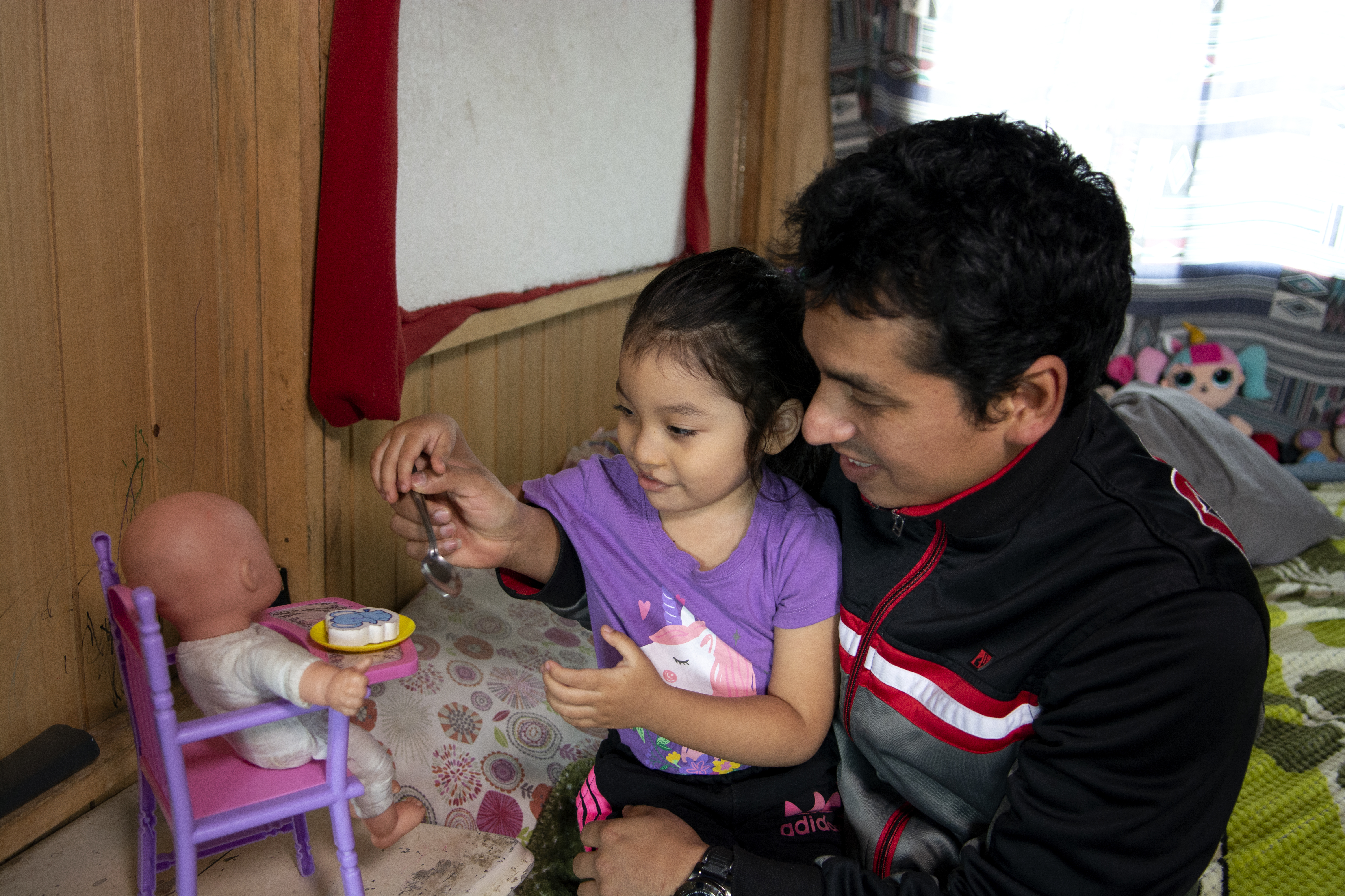 Itzayana and Sandro playing with a baby doll