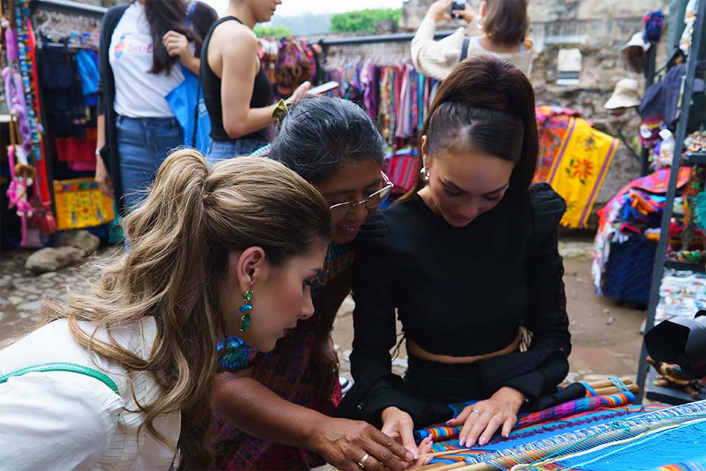 A Guatemalan woman teaches Miss Universe R’Bonney Gabriel how to weave