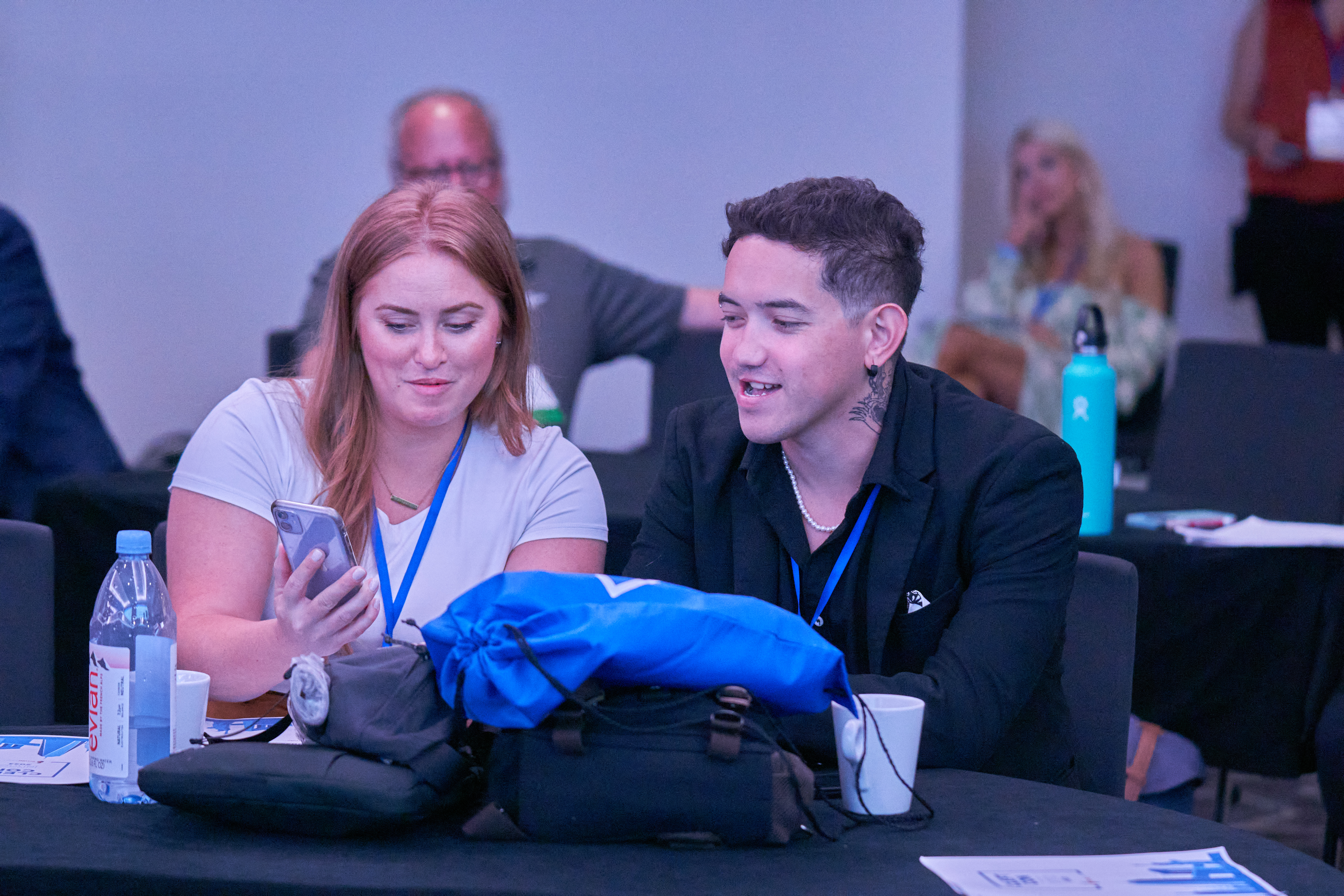Dillon sitting with a woman at Cleft Con New York as she shows him something on her phone