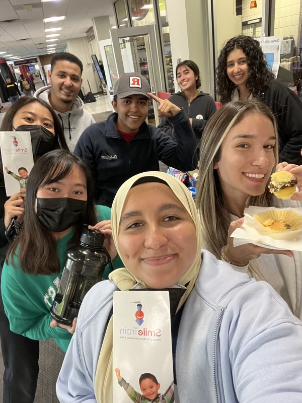 Project Dental All members taking a selfie holding Smile Train pamphlets and food from their bake sale