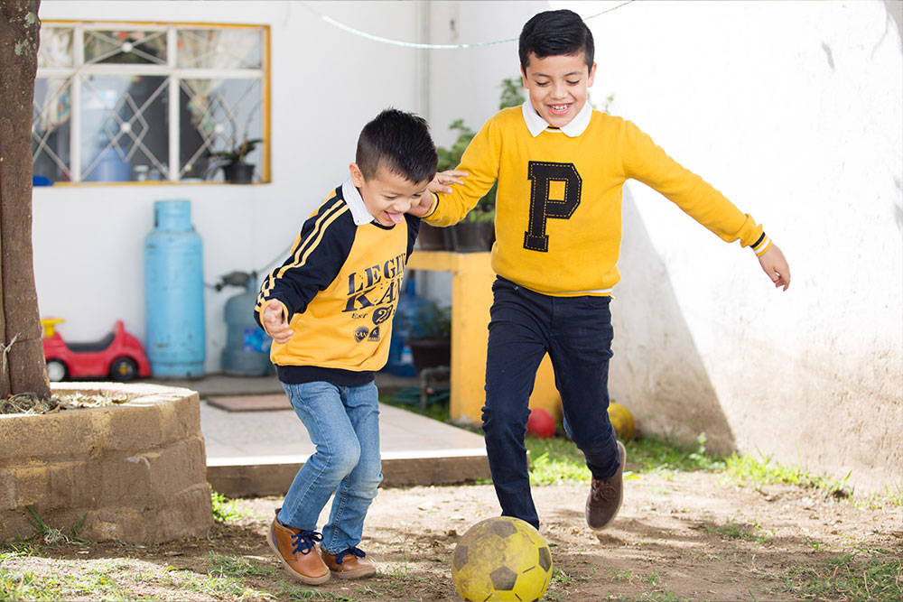 Alex and Carlos kicking a soccer ball